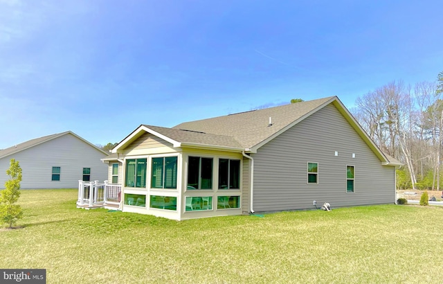 back of property featuring a sunroom and a lawn