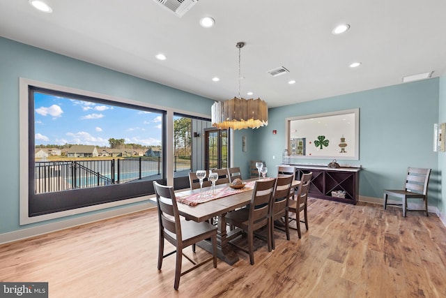 dining space with a chandelier and light hardwood / wood-style floors