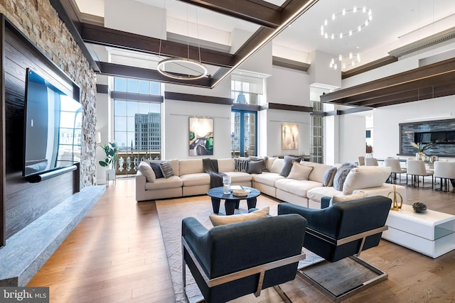 living room featuring a chandelier, a high ceiling, and light hardwood / wood-style flooring