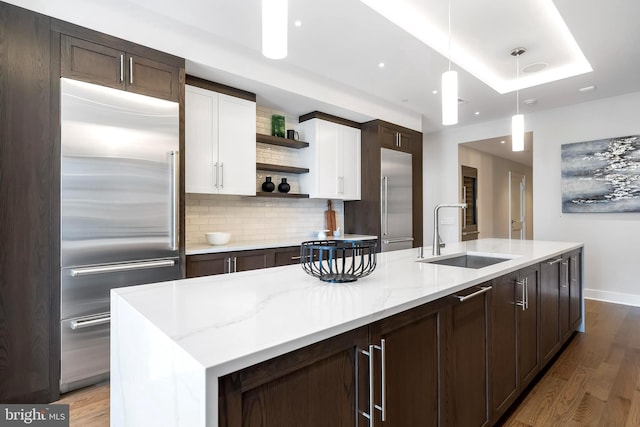 kitchen with sink, light wood-type flooring, white cabinetry, and high end refrigerator