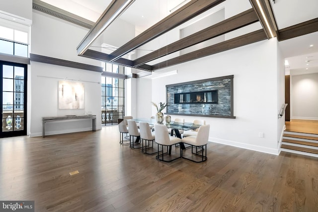 dining space featuring dark hardwood / wood-style floors and a high ceiling