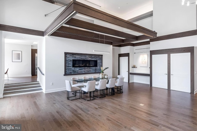 living room featuring dark hardwood / wood-style flooring, french doors, beam ceiling, and a stone fireplace