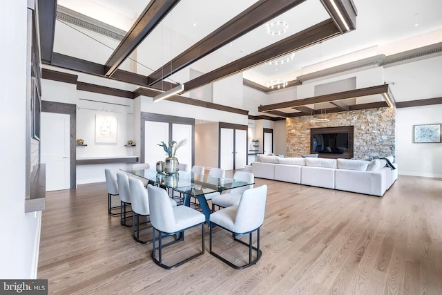 dining room with a stone fireplace and light wood-type flooring