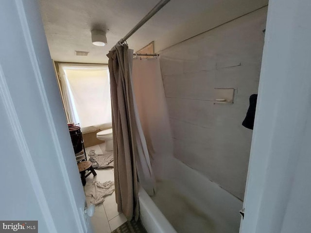 bathroom featuring tile floors, shower / bath combo, and toilet