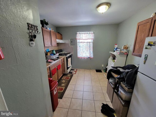 kitchen featuring white appliances and light tile floors