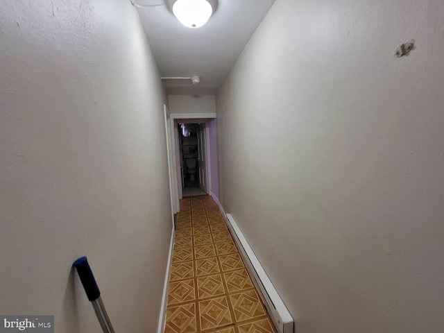 corridor with baseboard heating and tile flooring