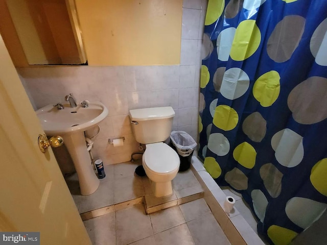 bathroom with toilet, backsplash, tile walls, sink, and tile floors