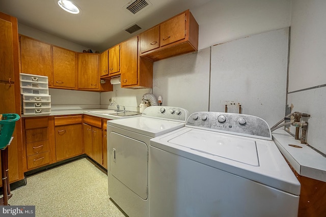 laundry area with cabinets, independent washer and dryer, and sink