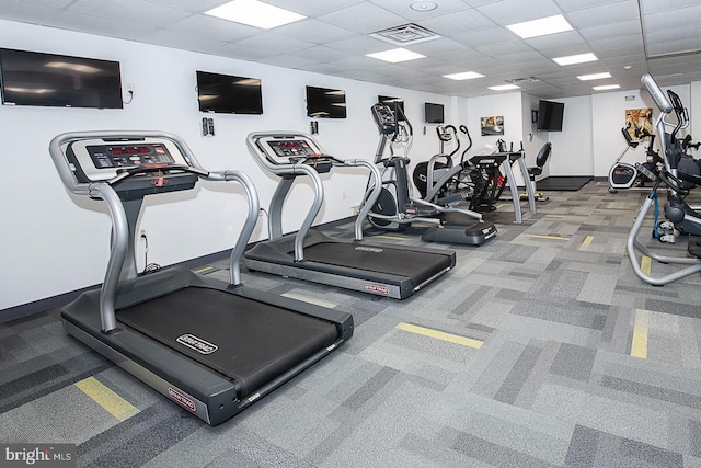 gym with carpet floors and a paneled ceiling