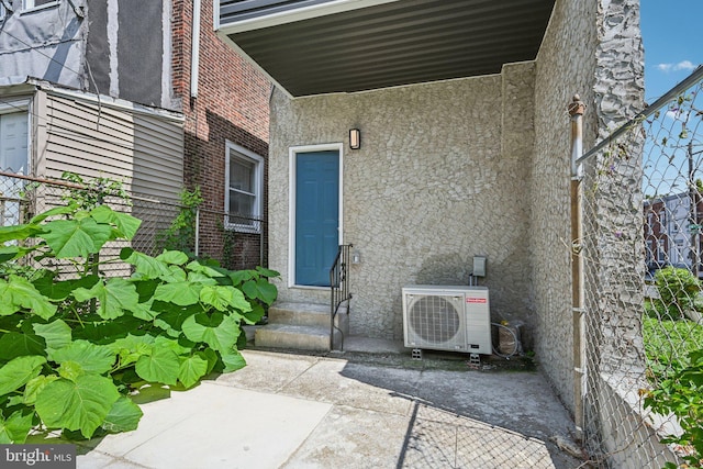 property entrance featuring ac unit and stucco siding