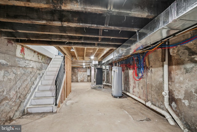 unfinished below grade area featuring gas water heater and stairway