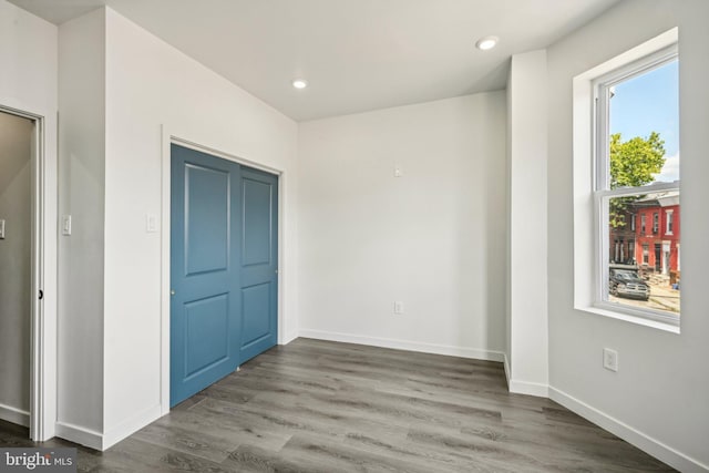 unfurnished bedroom featuring recessed lighting, wood finished floors, and baseboards