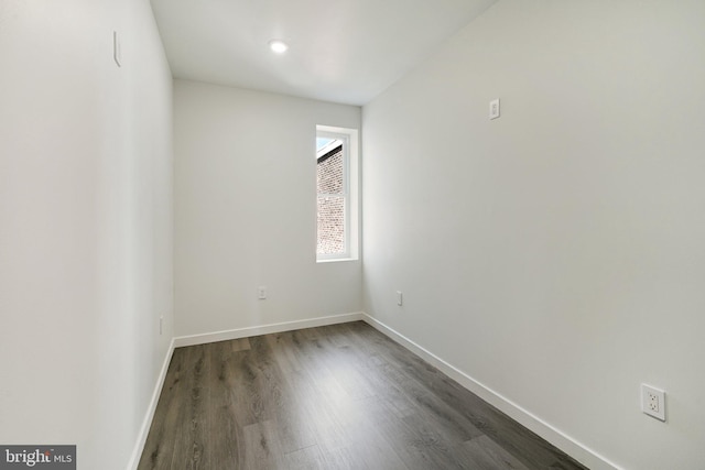 unfurnished room with dark wood-type flooring and baseboards