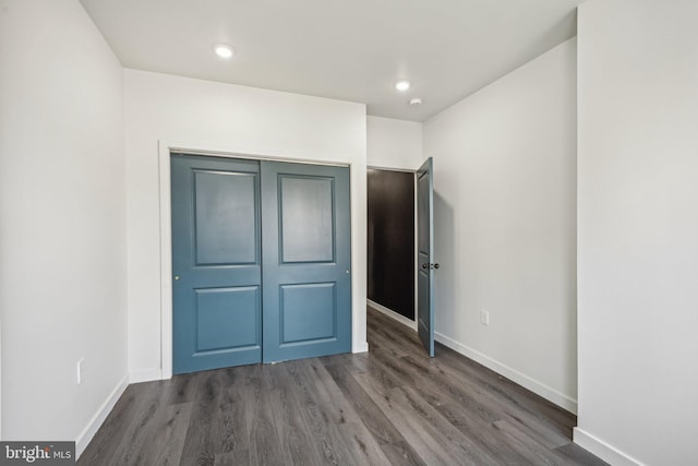 unfurnished bedroom featuring recessed lighting, wood finished floors, and baseboards