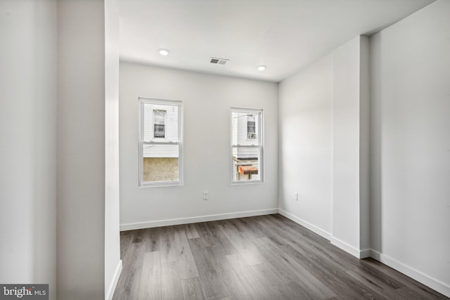 unfurnished room featuring recessed lighting, baseboards, visible vents, and dark wood-style flooring