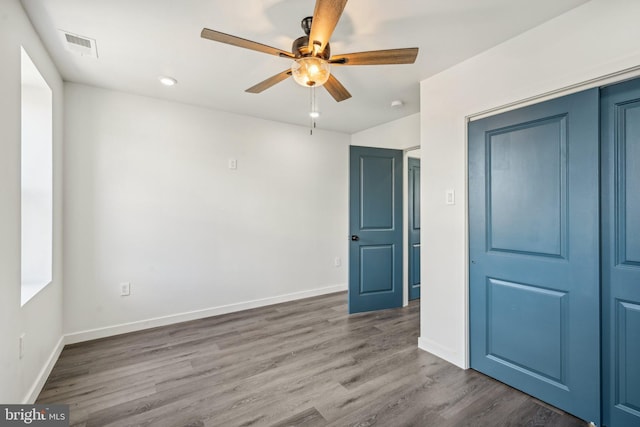 unfurnished bedroom with visible vents, baseboards, wood finished floors, and a ceiling fan