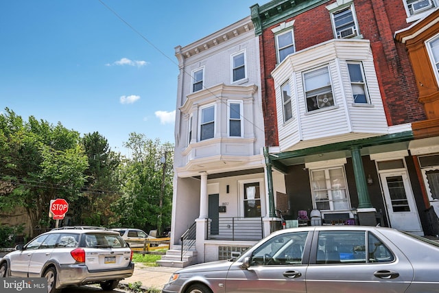 townhome / multi-family property with brick siding and covered porch