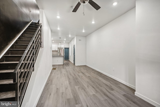 unfurnished living room with recessed lighting, light wood-style flooring, baseboards, and a ceiling fan