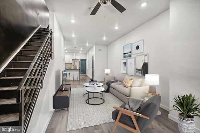 living area featuring stairway, wood finished floors, baseboards, recessed lighting, and ceiling fan