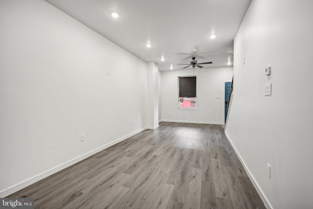 unfurnished living room featuring a ceiling fan, recessed lighting, wood finished floors, and baseboards