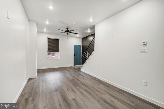 unfurnished living room featuring ceiling fan, baseboards, stairs, recessed lighting, and wood finished floors