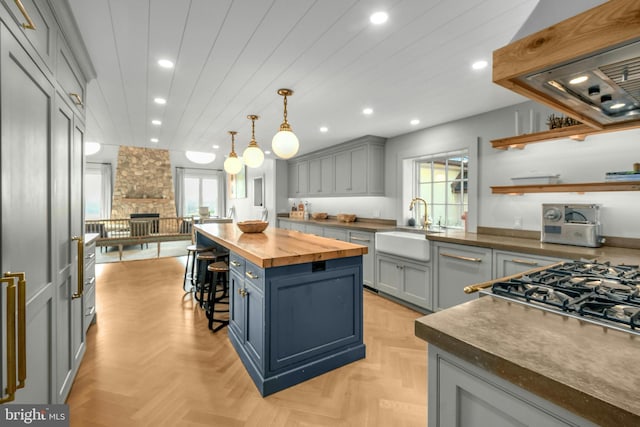 kitchen featuring custom range hood, plenty of natural light, light parquet flooring, and a center island