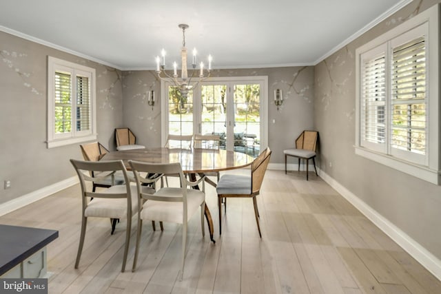 dining area with light wood-type flooring, a notable chandelier, and ornamental molding