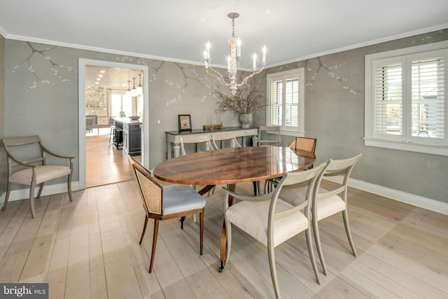 dining space featuring light hardwood / wood-style flooring, a notable chandelier, and ornamental molding