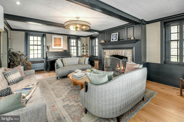 living room featuring hardwood / wood-style flooring, a fireplace, and beamed ceiling