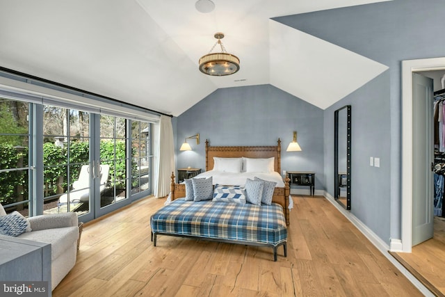 bedroom featuring access to outside, light hardwood / wood-style flooring, and lofted ceiling