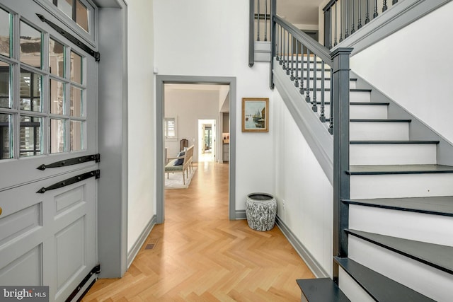 staircase with a high ceiling and parquet floors