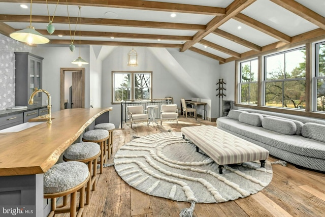 living room with vaulted ceiling with beams and hardwood / wood-style floors