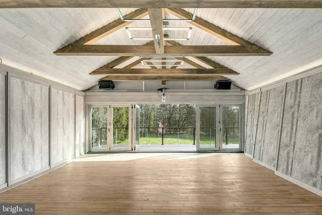 interior space with light wood-style floors and lofted ceiling with beams