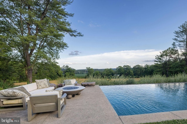 view of swimming pool featuring a patio and an outdoor fire pit