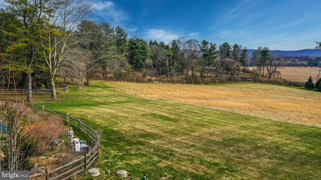 view of yard with a rural view and fence