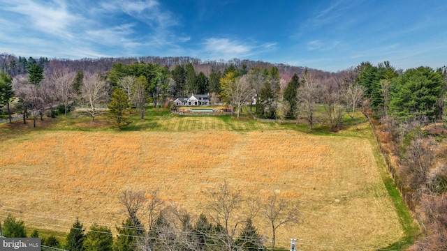 birds eye view of property featuring a wooded view and a rural view