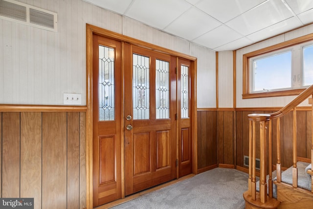 entrance foyer featuring a drop ceiling and light carpet