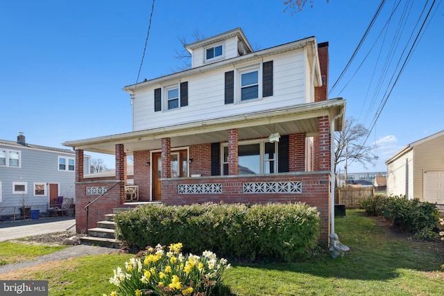 view of front facade with a front lawn and covered porch