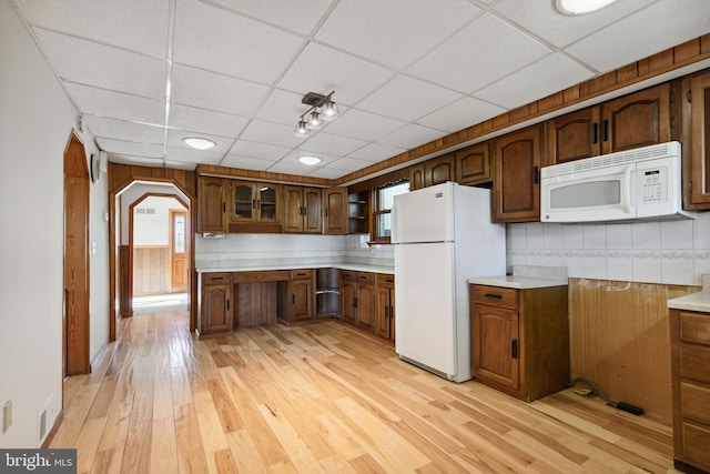 kitchen featuring light hardwood / wood-style flooring, white appliances, a wealth of natural light, and a paneled ceiling