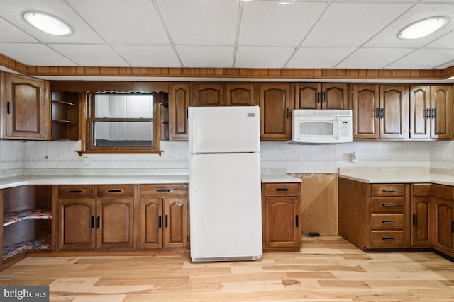 kitchen featuring light hardwood / wood-style flooring, white appliances, and a drop ceiling