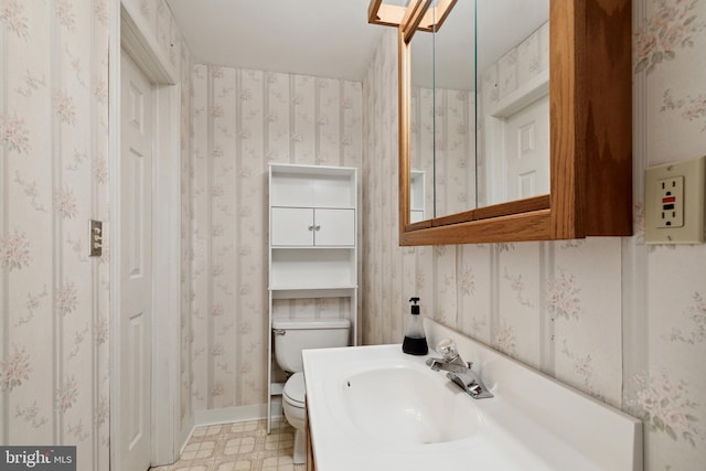 bathroom featuring toilet, sink, and tile flooring