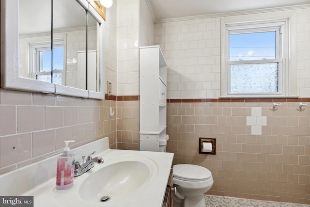 bathroom with tile walls, tasteful backsplash, toilet, and vanity with extensive cabinet space