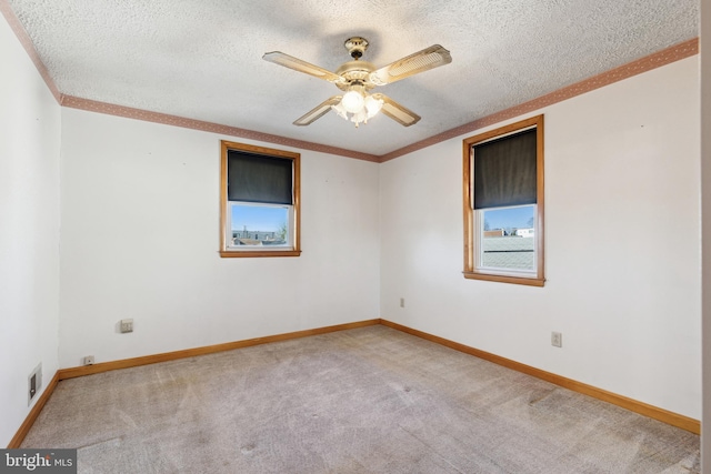 empty room with a textured ceiling, ceiling fan, and light colored carpet