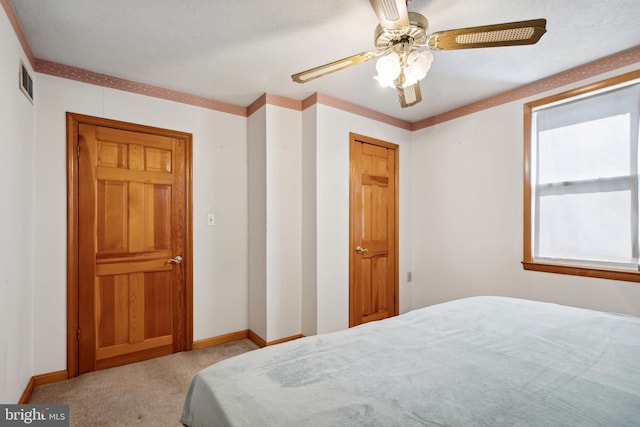 bedroom with ceiling fan, a closet, and ornamental molding