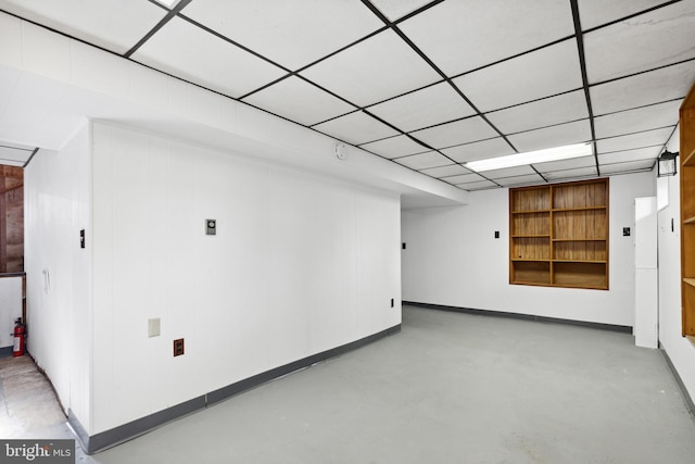 spare room with a paneled ceiling and built in shelves