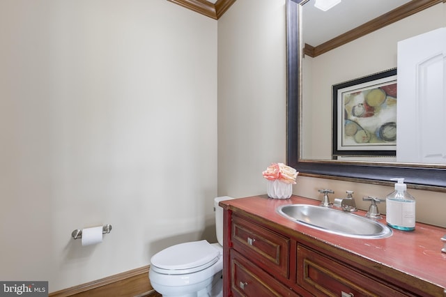 bathroom featuring toilet, vanity, and ornamental molding