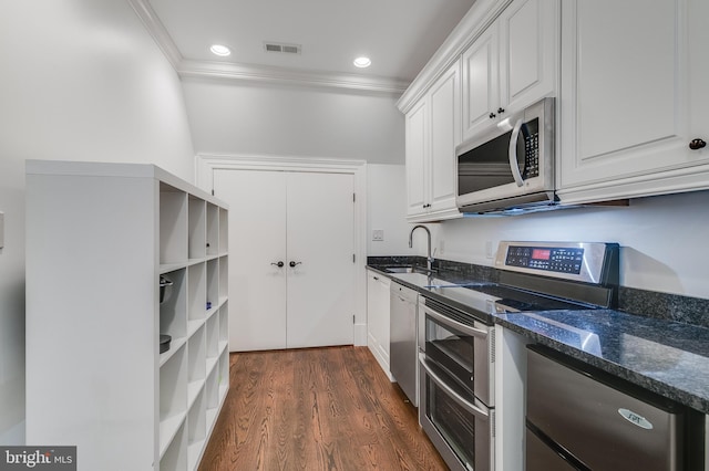 kitchen with stainless steel appliances, white cabinetry, dark hardwood / wood-style floors, and dark stone counters