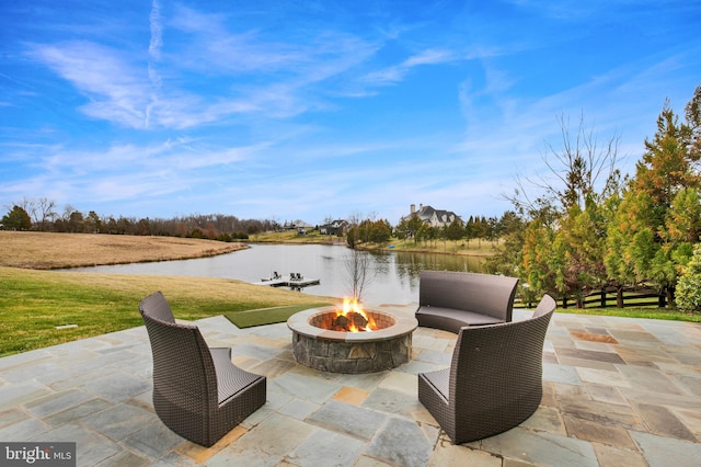 view of patio with a fire pit and a water view