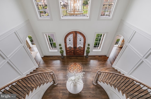 entryway with french doors, dark wood-type flooring, a high ceiling, and a notable chandelier