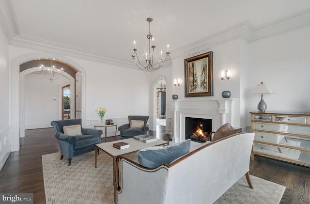 living room with dark hardwood / wood-style floors, crown molding, and a chandelier